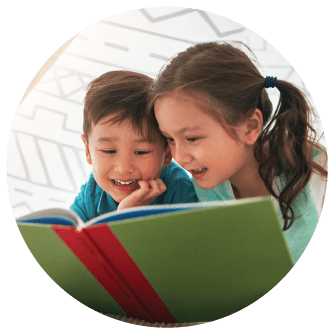 two children reading a book together