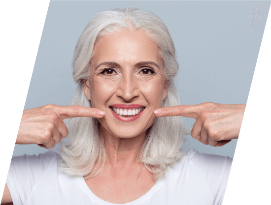 senior woman pointing to her white smile