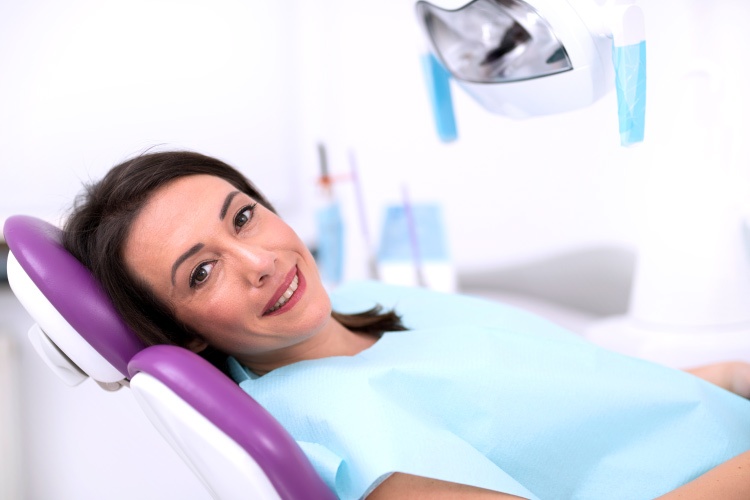 Smiling brunette woman in dental chair awaiting treatment