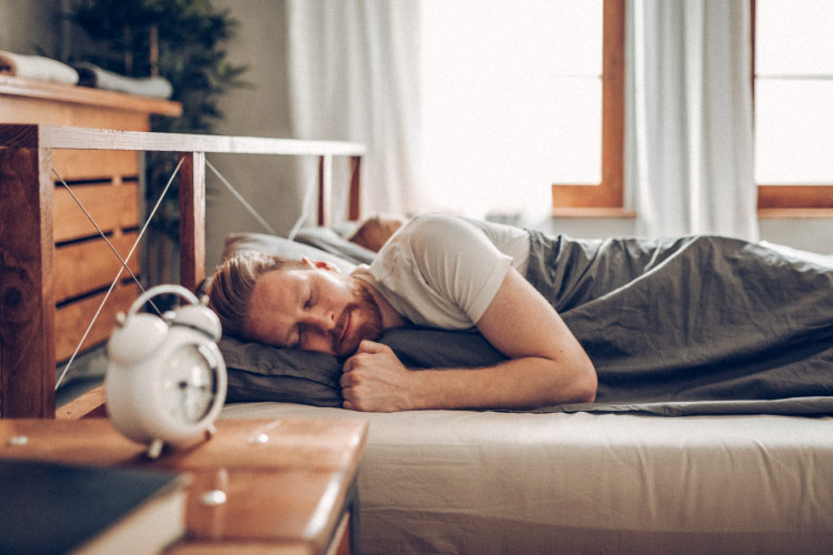 man in bed after getting dental implants