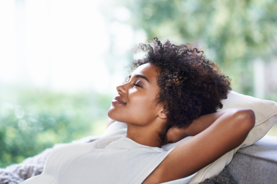 Young woman relaxing on a hammock on the patio to reduce dental anxiety.