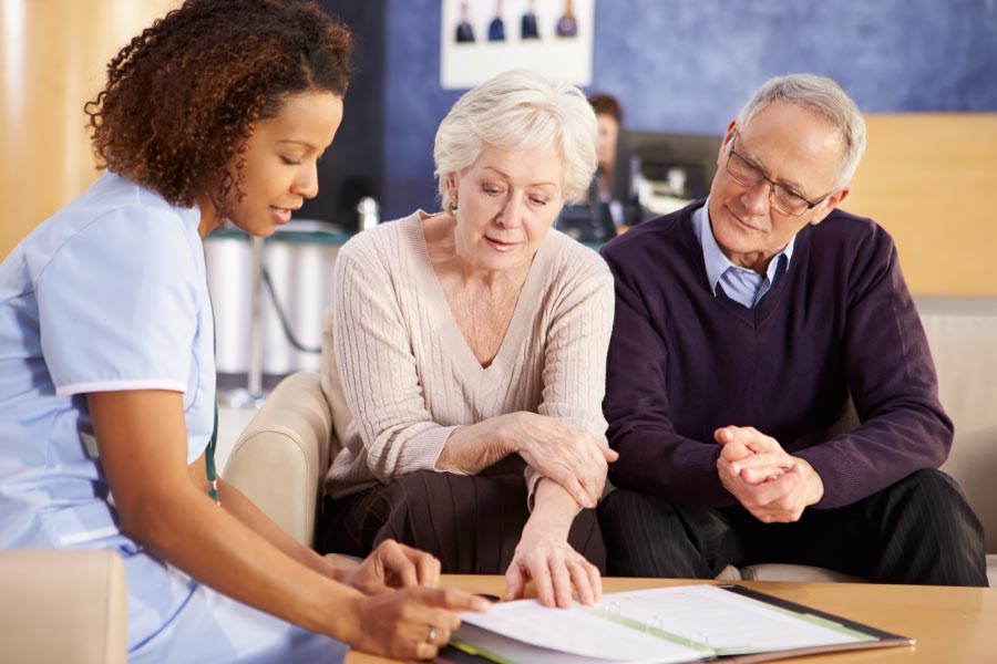 A mature couple conferring with a medical professional.