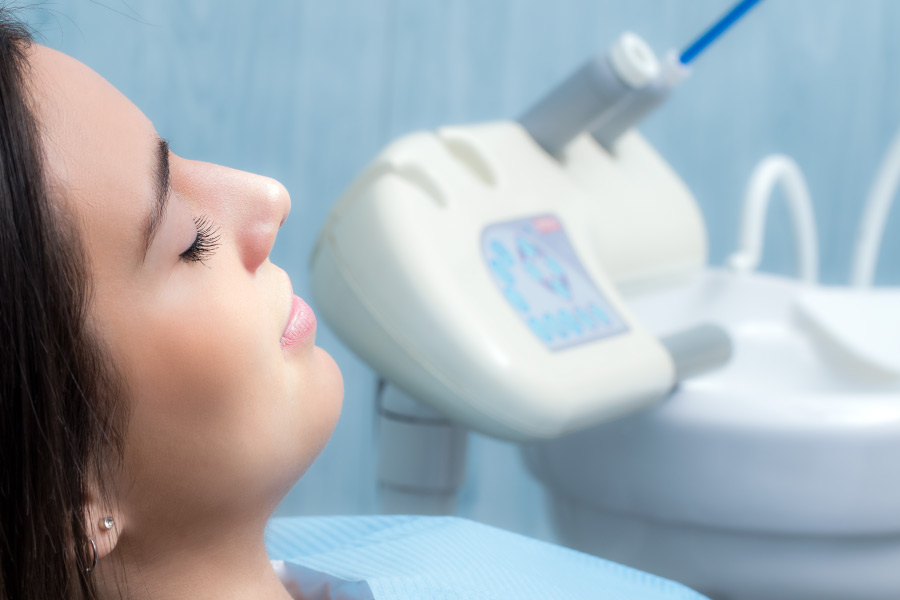 A woman relaxes in the dental chair after receiving dental sedation.