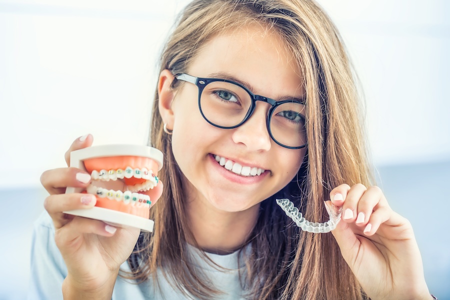 teen comparing braces or clear aligners for orthodontics